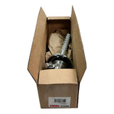 Automotive shock absorber or strut partially visible inside a cardboard shipping box.