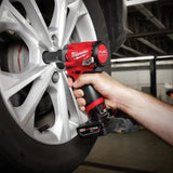 Red Milwaukee battery impact wrench in action on a car wheel, part of the Stubby Impact Wrench Kit