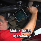 Mechanic using a tablet while working underneath a vehicle.