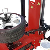 Tire-changing machine with a red body and mechanical components for mounting and dismounting vehicle tires.