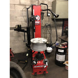 Tire changing machine with a red and black color scheme.